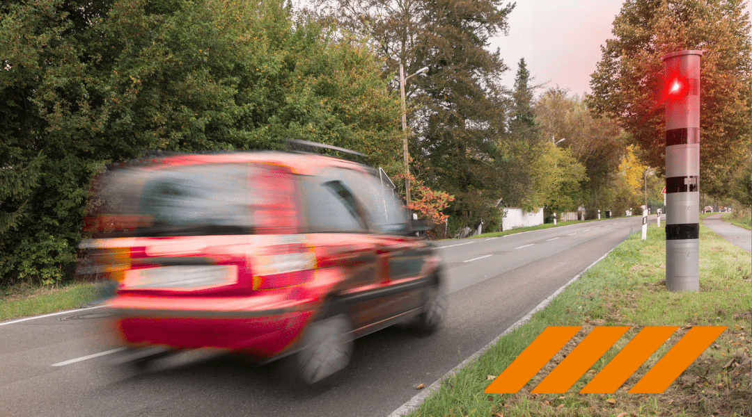 Rotes Auto fährt bei Sonnenschein in Delmenhorst an Blitzer vorbei – sicheres Fahren mit ASF-Seminar der Fahrschule Wichmann.
